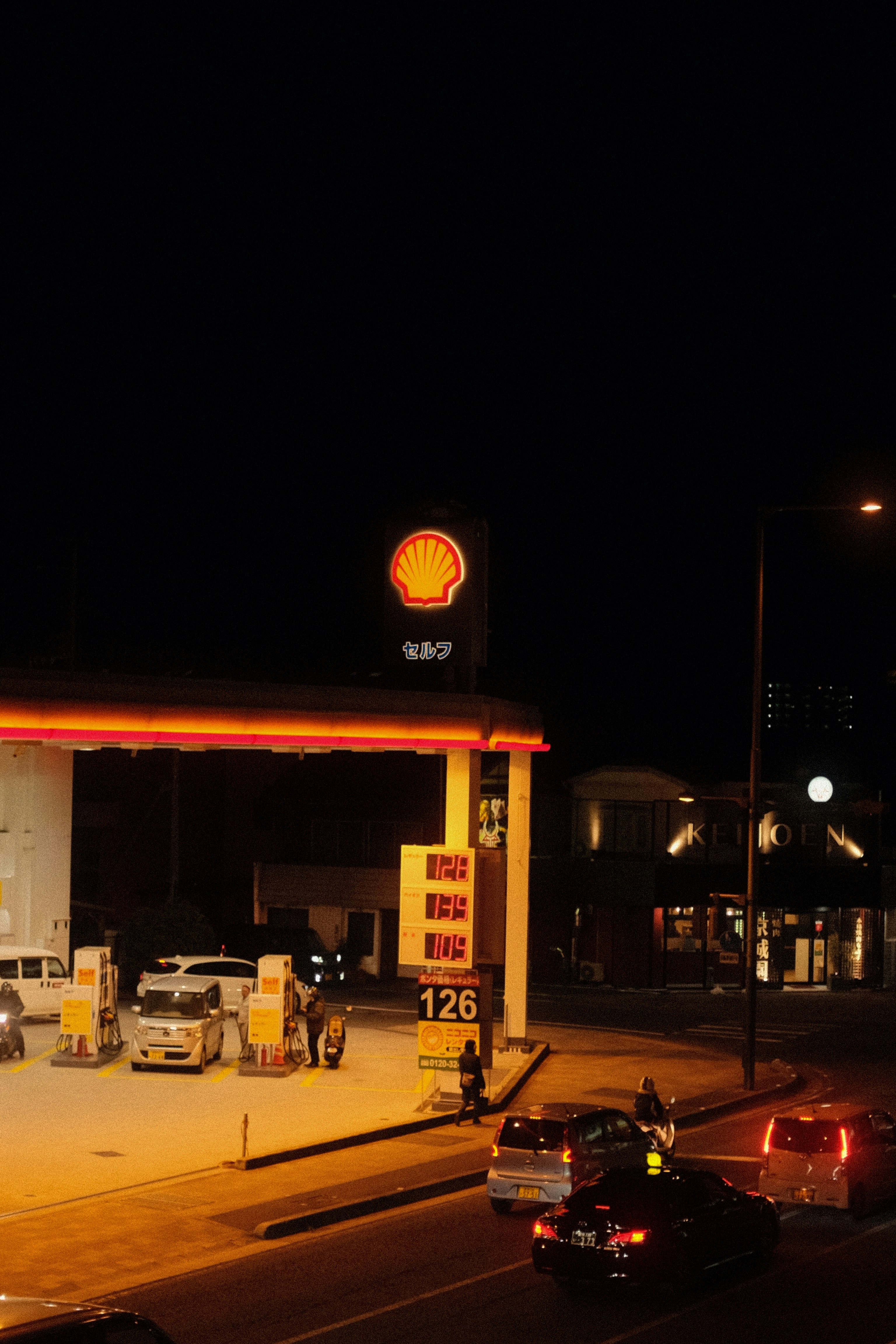 cars parked in front of white and red building during night time